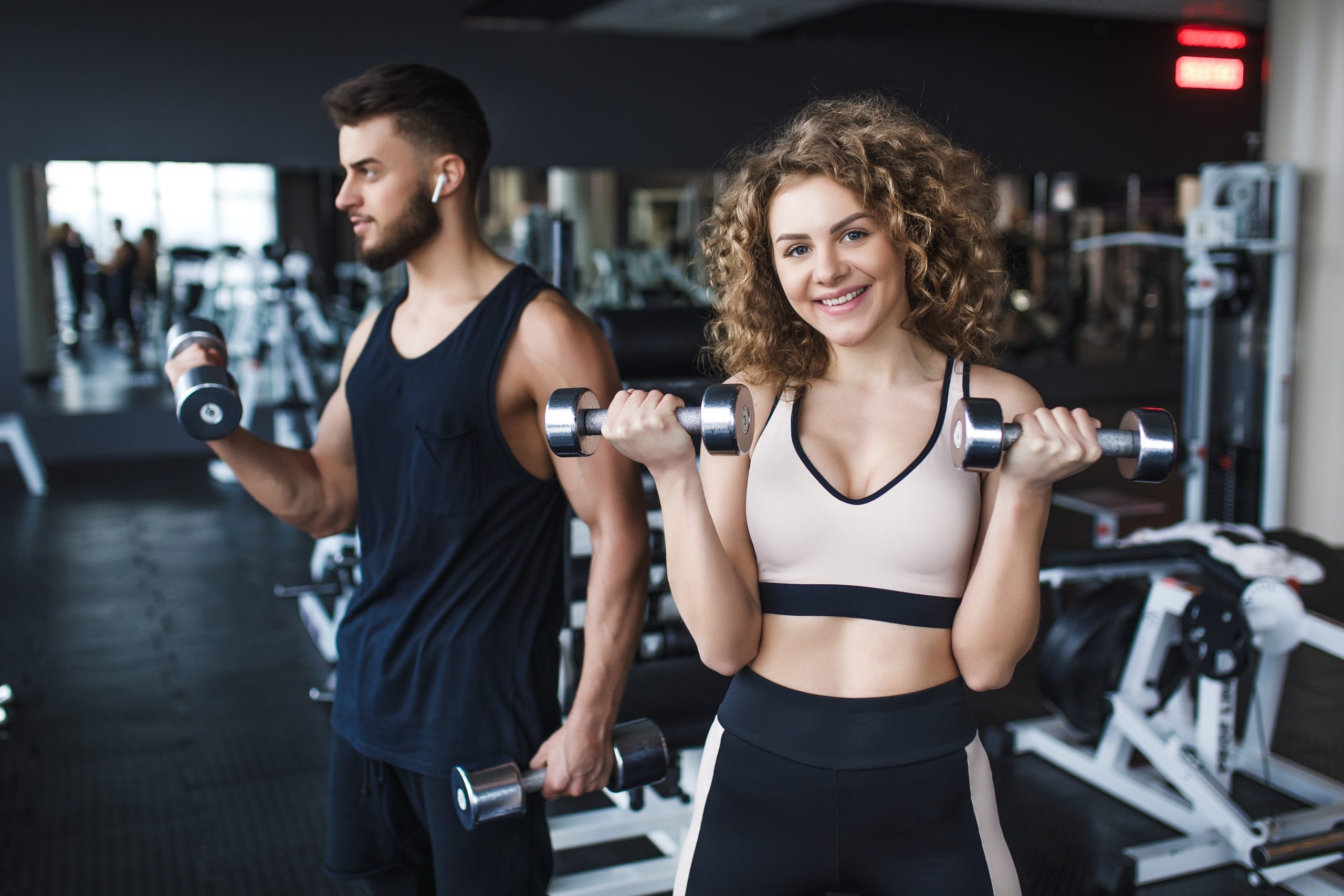 Beautiful Young Sporty Couple Trainer and Woman Showing Muscle a Gift Gift